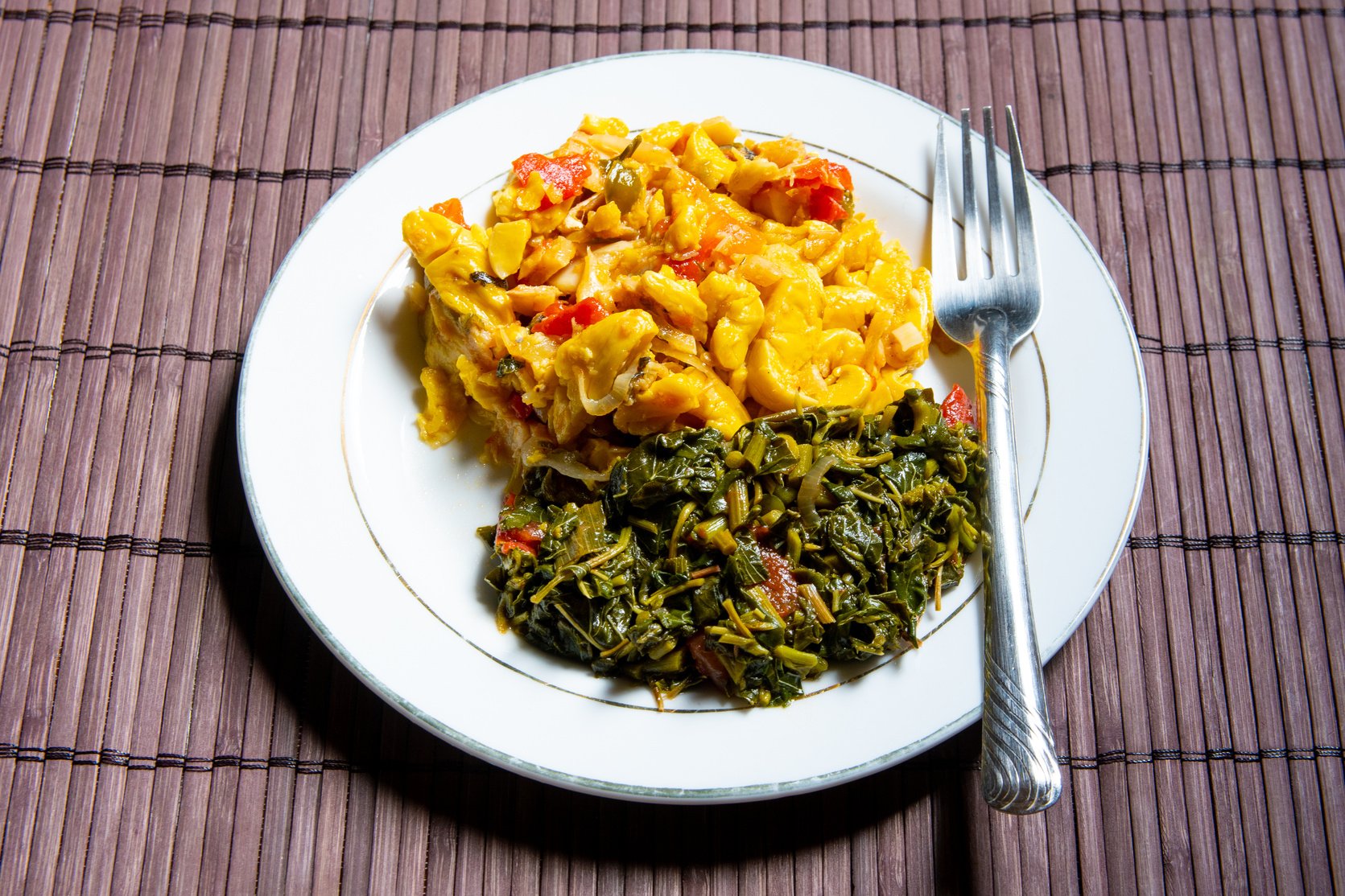 Famous traditional Jamaican ackee & saltfish breakfast, steamed callaloo seasoned with tomatoes, thyme, onions, escallion (scallion).